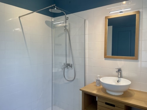 Modern bathroom at Château de Vaux Morvan cottage with walk-in shower, vessel sink, and wooden vanity