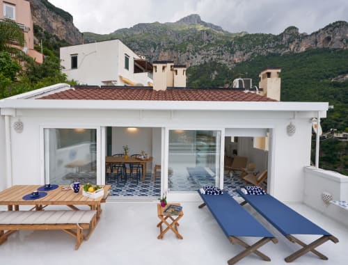 Terrazza moderna sul lungomare di Wonderful Positano con lettini, zona pranzo e spettacolari scogliere di Positano sullo sfondo
