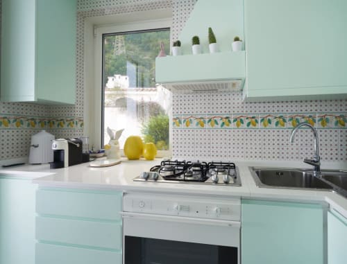 Cucina verde menta all'hotel Wonderful Positano con piano cottura a gas, lavello, piastrelle decorative e finestra con vista su Positano