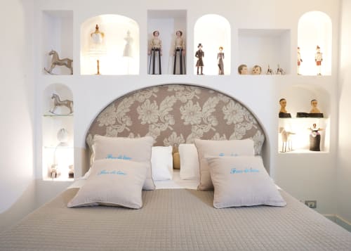 Camera da letto elegante dell'hotel Wonderful Positano con testata damascata, ripiani decorativi e cuscini blu ricamati