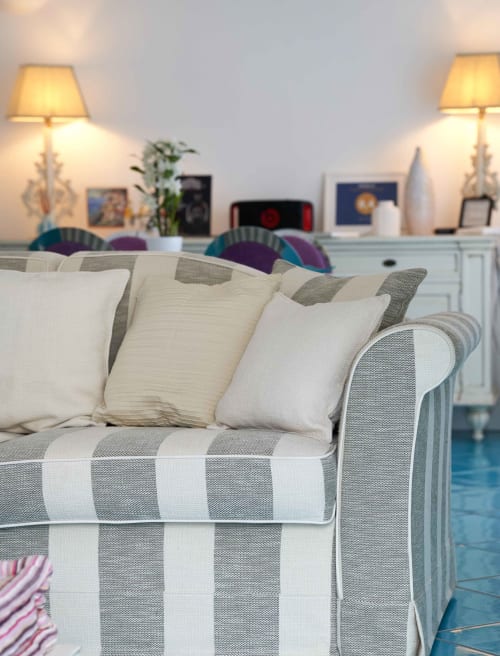 Divano rigato con cuscini color crema nella luminosa sala living dell'hotel Wonderful Positano, Positano Italia