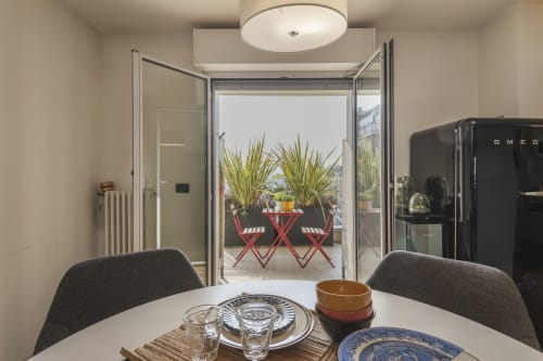 Moderna zona pranzo con vista sulla terrazza dell'appartamento GIRESIO 41 a Milano, con tavolo apparecchiato e accesso all'esterno