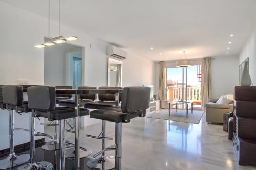 Moderno apartamento SACORO en Marbella con salón abierto, vistas al mar, barra y mobiliario contemporáneo