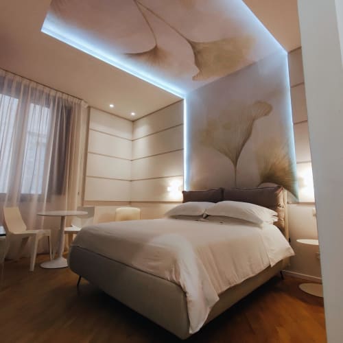 Modern Junior Suite Superior bedroom at Stella CasaBono hotel in Sulmona with contemporary lighting and ginkgo leaf artwork
