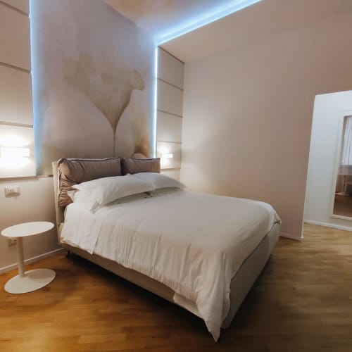 Modern Junior Suite Superior bedroom at Stella CasaBono hotel in Sulmona with queen bed, ambient lighting, and wooden