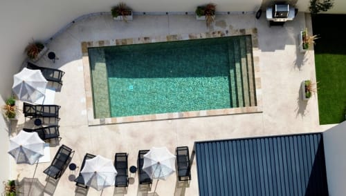 Vista aerea della piscina riscaldata della villa La Maison D'ambrine con lettini e ombrelloni a Chamaret, Francia