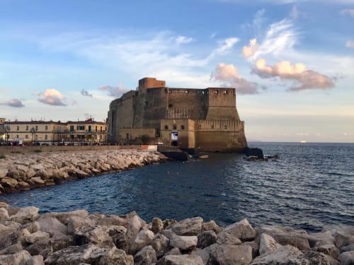 Fortezza Castel dell'Ovo sulla baia di Napoli con edifici storici e costa rocciosa