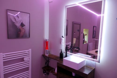 Modern romantic bathroom with pink neon lighting, illuminated mirror, and spa amenities at Les Secrets de Winna boutique