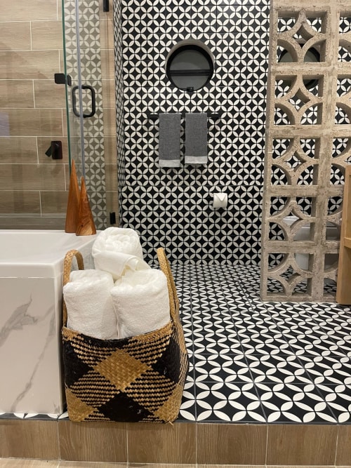 Baño moderno en el hotel Casa Donceles de la Ciudad de México con azulejos estampados en blanco y negro, cesto de toallas tejido y ducha abierta