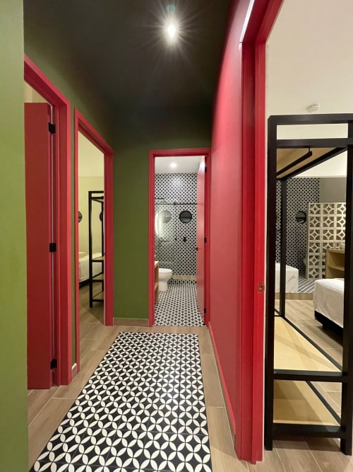 Pasillo moderno con puertas rojas y paredes verde lima en Casa Donceles, departamento de Ciudad de México con patrón geométrico