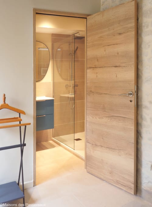 Salle de bain moderne avec douche à l'italienne et porte en bois au Vaudoué, pays de Fontainebleau, parc régional du Gâtinais