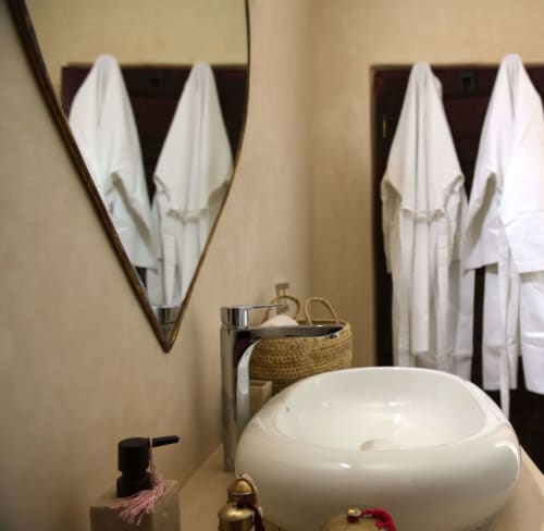 Luxe badkamer in Riad Palau Marrakech met witte handdoeken, keramische wastafel en spa-faciliteiten