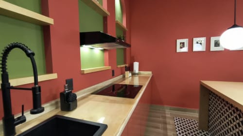 Cocina moderna del apartamento Casa Colores en Casa Donceles, Ciudad de México, con paredes rojas, equipos negros e inducción