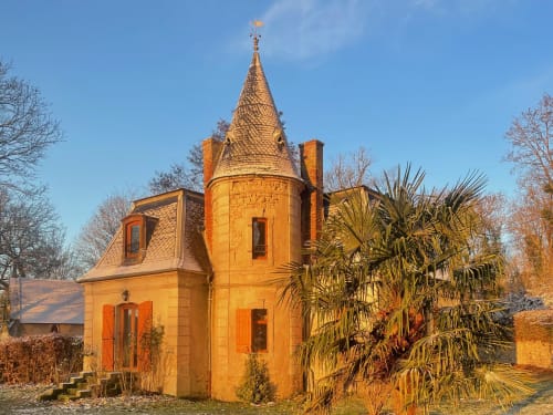 Historic golden stone tower with conical roof at Château de Vaux Morvan bed and breakfast in Étang sur Arroux, France