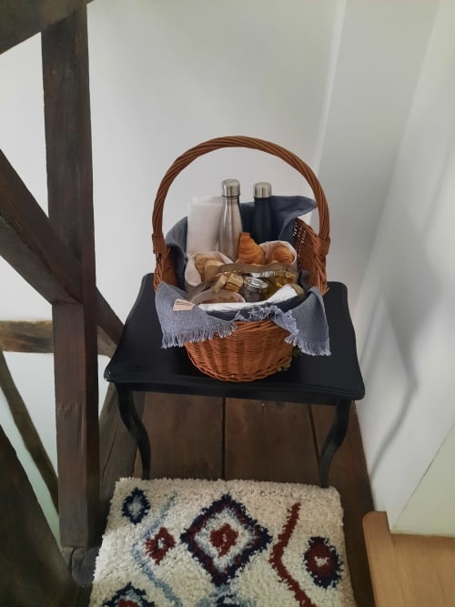 Panier tressé avec articles de pique-nique sur table noire à la Maison Rinette B&B Dijon