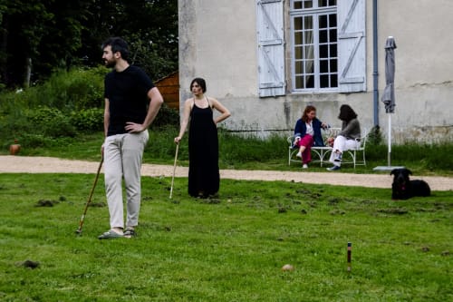 Des clients jouent aux boules dans le jardin du Château de Vaux Mordan, un gîte de charme en Bourgogne.