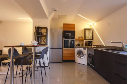 Cuisine moderne du Domaine du haut de la Dombes avec appareils en inox, mobilier noir et espace repas