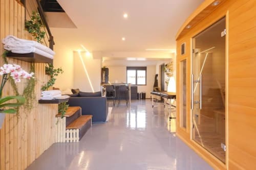 Couloir spa du Domaine du haut de la Dombes avec finitions en bois, équipements bien-être et éclairage élégant
