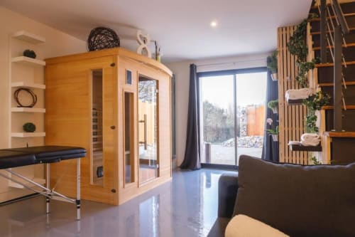 Villa spa moderne au Domaine du haut de la Dombes avec sauna en bois, transat noir, vue sur le jardin et étagères en bois