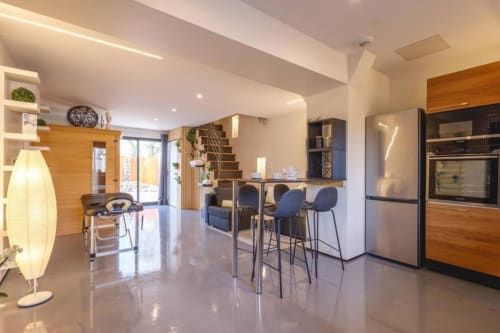 Cuisine et salle à manger de villa moderne avec appareils électroménagers en acier inoxydable, bar et vue sur le jardin