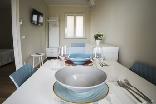 Tavolo da pranzo moderno presso Residence Balconi del Conero a Marcelli con piatti bianchi, dettagli blu e design elegante