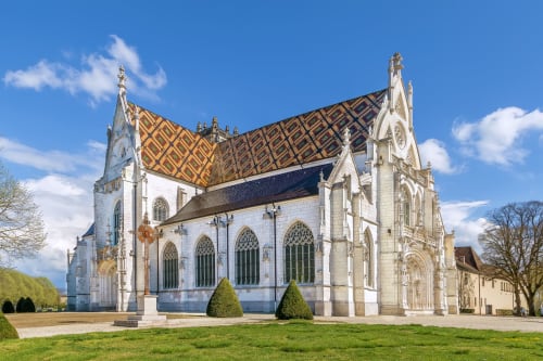 Chapelle historique en pierre blanche avec un toit aux motifs jaunes distinctifs à Châtillon-sur-Chalaronne, France