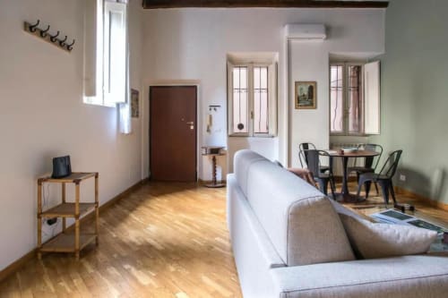 Luminoso soggiorno a Roma vicino a Campo de' Fiori con divano, tavolo da pranzo, parquet e comfort moderni