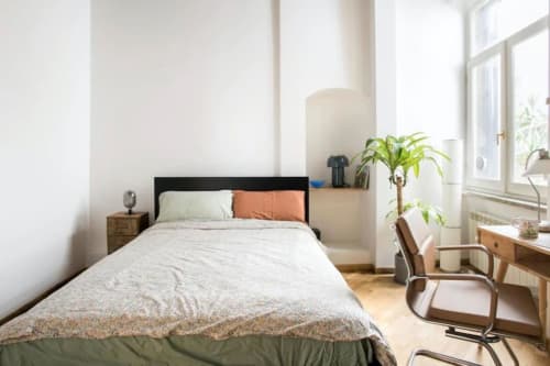 Camera luminosa in appartamento romano vicino a Campo de' Fiori con letto, scrivania, pianta e luce naturale dalle finestre