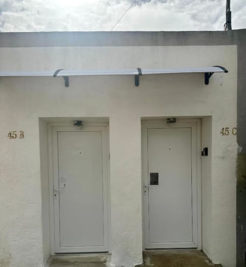 Entrada privada do Apartamento Jorge em Sintra Apartamentos, com duas portas brancas numeradas 45B e 45C e grade de metal