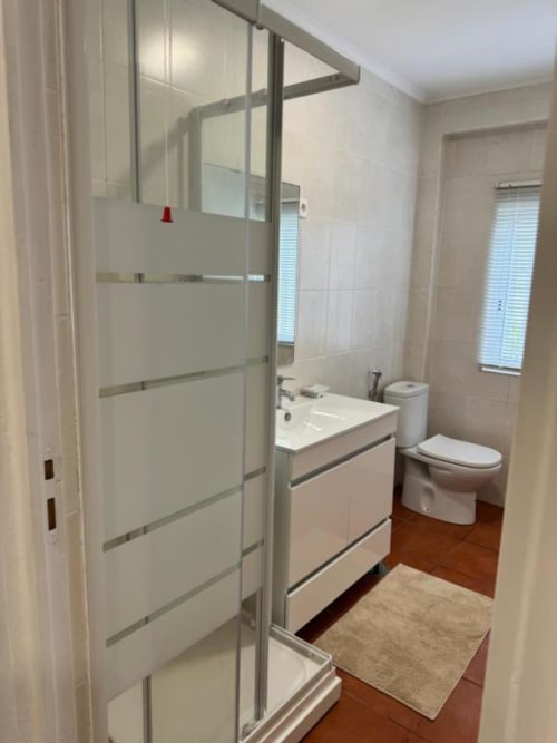Casa de banho moderna no Apartamento Jorge da Sintra Apartamentos com box de vidro, lavatório e sanita