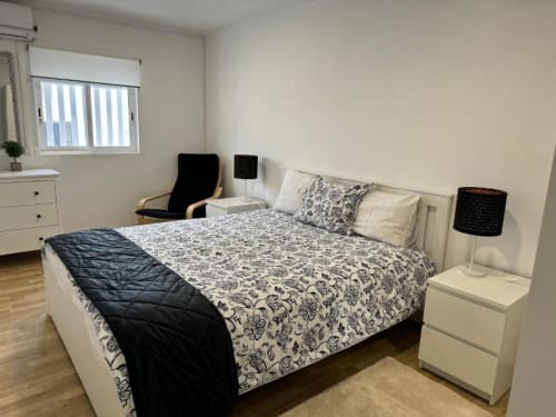 Quarto do Apartamento Jorge em Sintra Apartamentos com cama de casal, roupa de cama estampada, mesinhas e design moderno