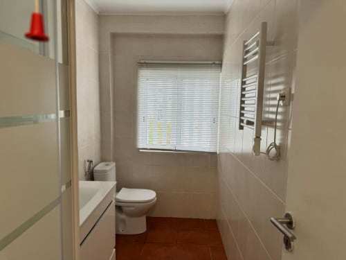 Banheiro moderno no Apartamento Jorge em Sintra Apartamentos com sanitário, pia, aquecedor de toalhas e box de chuveiro