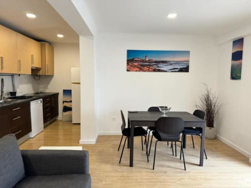 Área de refeições do Apartamento Jorge em Sintra com cozinha, mesa, cadeiras e obras de arte costeira em paredes brancas