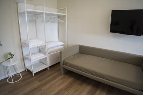 Studio apartment bedroom with sofa bed, wardrobe, and flat-screen TV at Residence Balconi del Conero, Marcelli