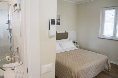 Bright studio apartment bedroom with bed, shower room, window, and sea view at Residence Balconi del Conero, Marcelli