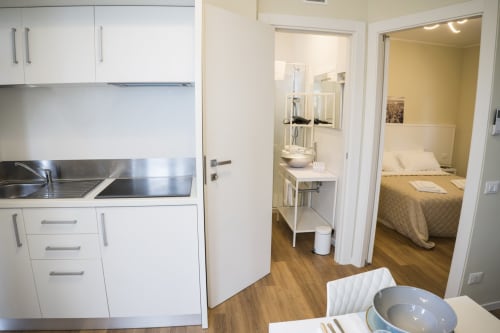 Residence Balconi del Conero appartamento 04: angolo cottura moderno, bagno, camera con pavimenti in legno e cortile interno