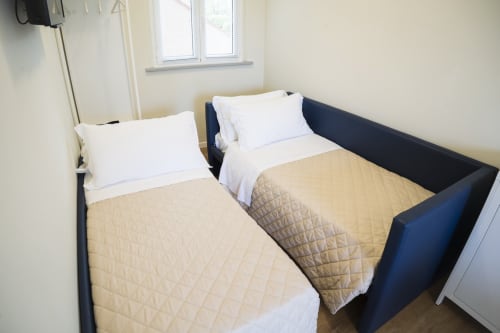 Due letti singoli con cuscini bianchi e trapunte beige in una luminosa camera presso Residence Balconi del Conero, Marcelli