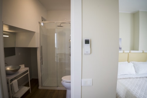 Modern apartment bathroom with shower, toilet, and sink connected to bedroom at Residence Balconi del Conero, Marcelli