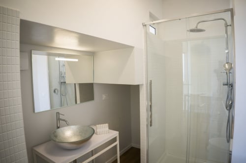 Modern bathroom with vessel sink, illuminated mirror, and glass shower enclosure at Residence Balconi del Conero apartment in