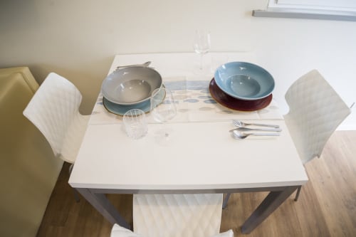 Dining table set for two at Residence Balconi del Conero apartment with place settings, glasses, and dinnerware