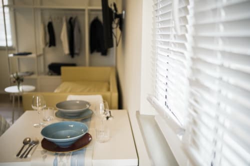 Modern apartment dining area at Residence Balconi del Conero with set table, blue dishware, white shutters, and wardrobe
