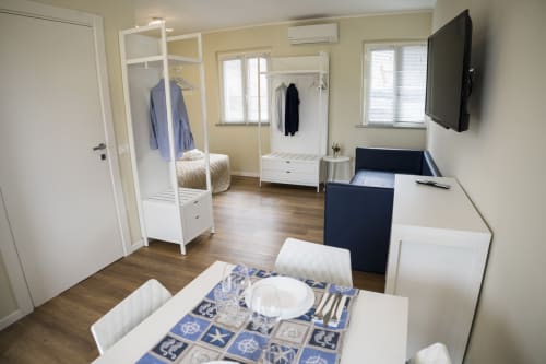 Accessible apartment interior at Residence Balconi del Conero with dining area, wardrobe, beds, and TV