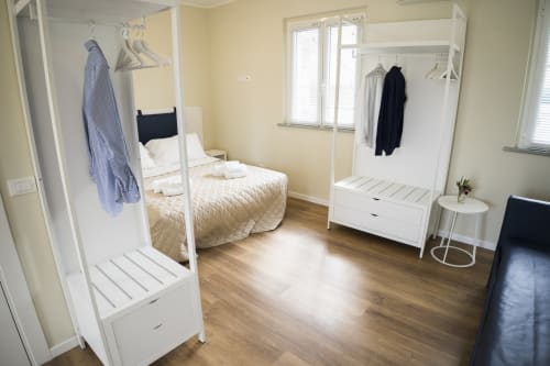 Accessible apartment bedroom at Residence Balconi del Conero with bed, white wardrobe, clothing racks, and wood flooring in