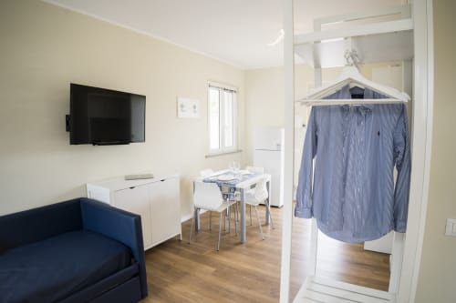 Accessible apartment at Residence Balconi del Conero with TV, kitchenette, dining table, sofa bed, and clothesline in
