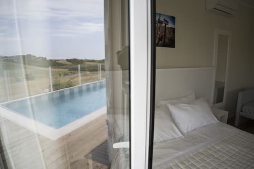 Modern bedroom with pool view at Residence Balconi del Conero, Marcelli. Comfortable bed overlooks sparkling pool and
