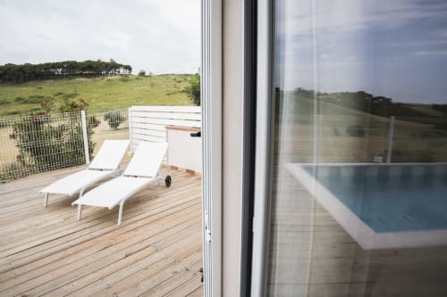 Wooden deck with white loungers and pool view at Residence Balconi del Conero in Marcelli