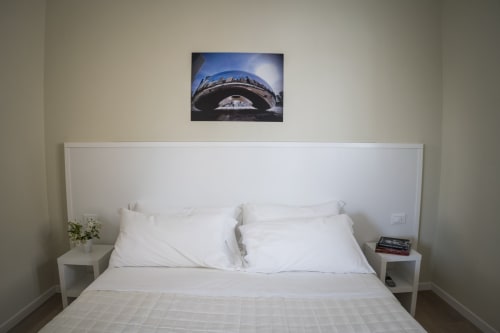 Modern bedroom at Residence Balconi del Conero with white bed, nightstands, and contemporary wall art in Marcelli, Ancona