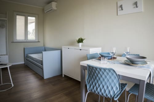 Modern apartment at Residence Balconi del Conero in Marcelli featuring dining table, sofa bed, and kitchenette with ocean