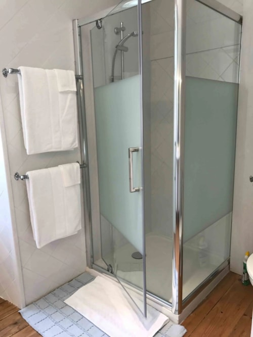 Salle de bain moderne avec douche à l'italienne, double vasque et porte-serviettes blancs au Manoir De Rieuzal à Loubressac
