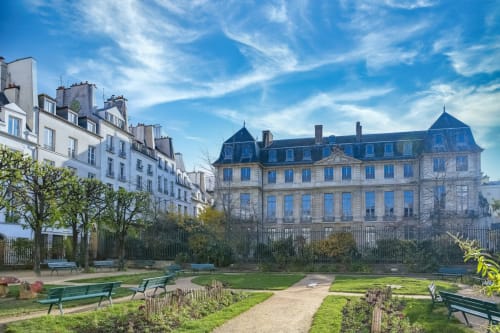 Hôtel particulier parisien aux toits mansardés bleus et jardins soignés de l'hôtel Chez Adrien Paris